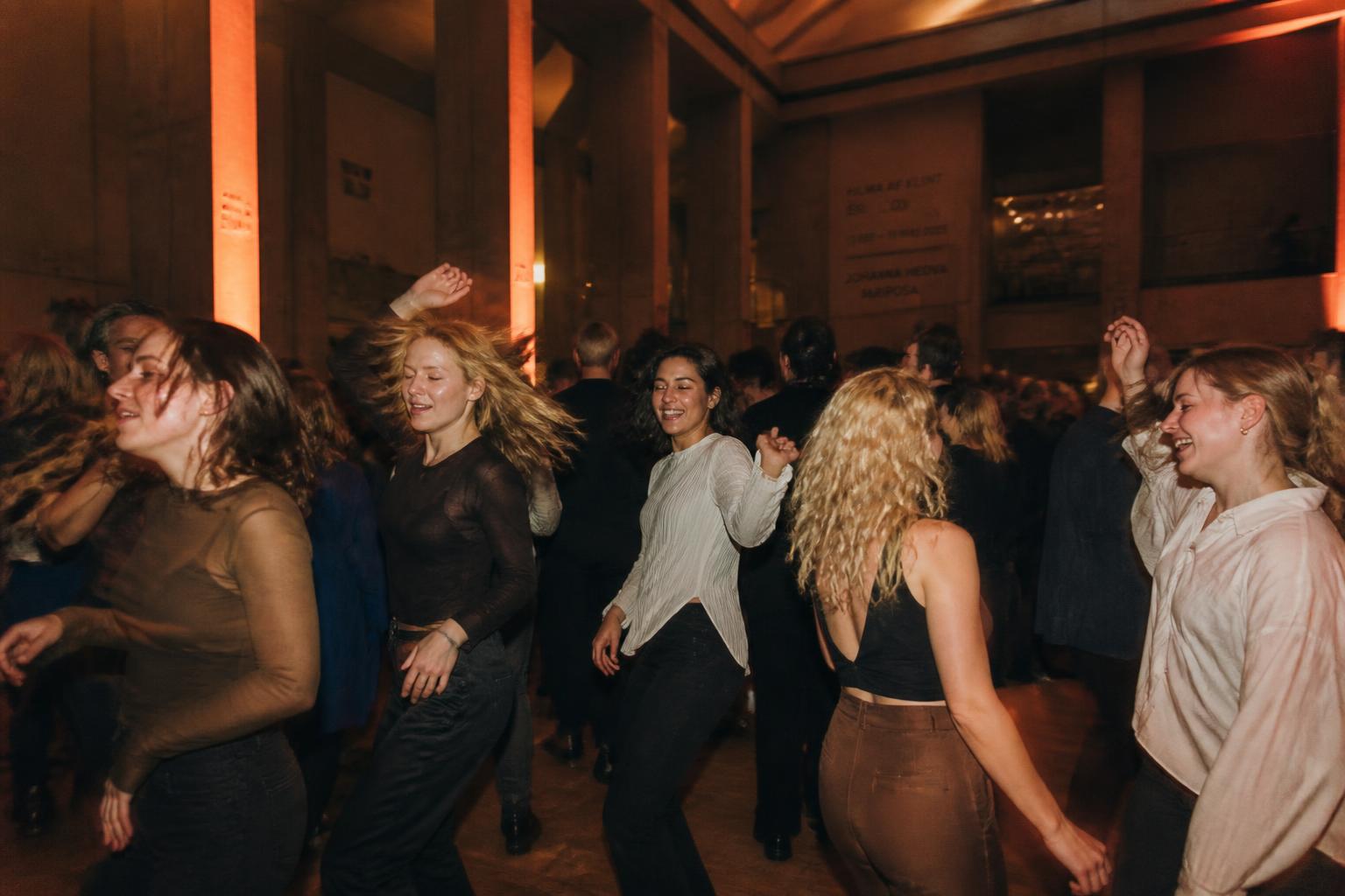 Friends dancing together in a Stockholm museum hall